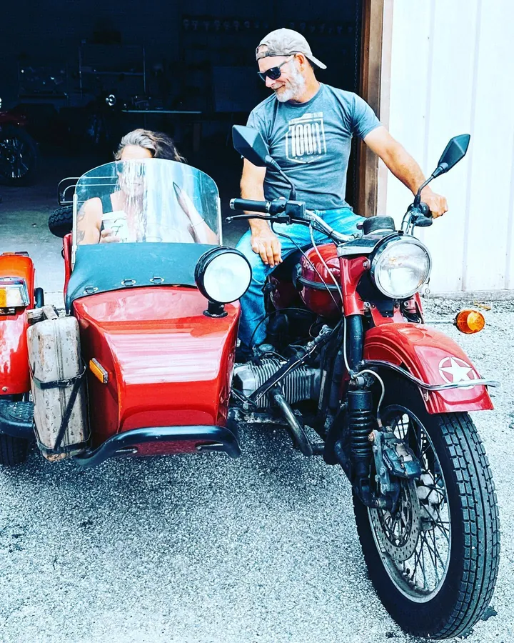 David on their red Ural with Mel in the sidecar
